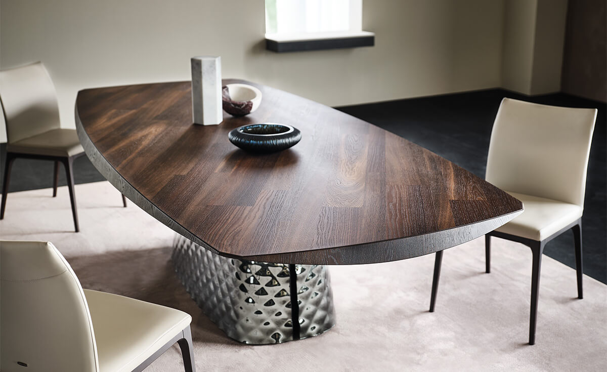 4ea013bb-d9ed-4528-8d72-01184c74e617 Cattelan Italia's Atrium Masterwood dining table burned oak wooden carved top and metal quilted base closeup detail shot at base slit.