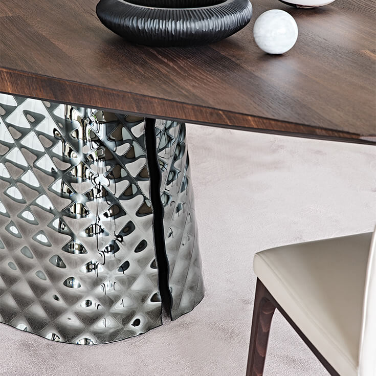 6b861d84-1059-48fe-98d4-2dd172b594c3 Cattelan Italia's Atrium Masterwood dining table burned oak wooden carved top and metal quilted base closeup detail shot at base slit.