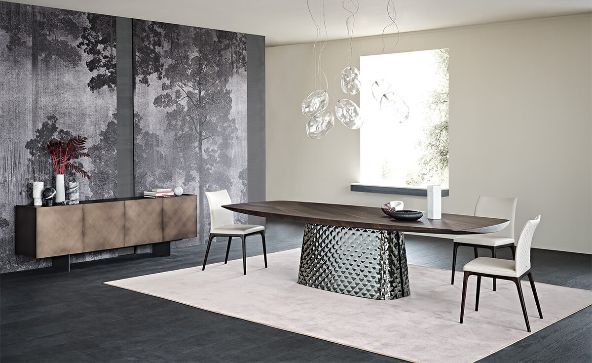 b4d33564-c403-4687-82a6-7bbae5854e23 burned oak wooden carved top and metal quilted base in an empty room with white leather dining chairs